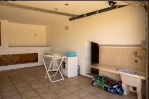a room with a kitchen with a sink and a washing machine at Orsa sul mare a Baja Sardinia in Cala Bitta