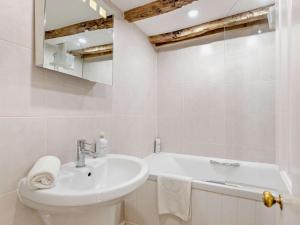a white bathroom with a sink and a bath tub at 2 Bed in Broadway oc-28985 in Broadway +21 photos