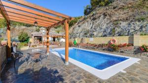 a patio with a pool and a table and chairs at Villa La Cola Nerja by Ruralidays in Nerja