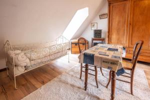 a bedroom with a bed and a table and chairs at Chambres d'hôtes ''La Grand' Maison'' in Escalles