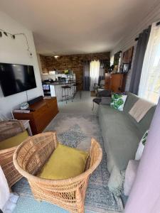 a living room with a couch and wicker chairs at Hemel in Hermanus Three bedroom Home in Hermanus