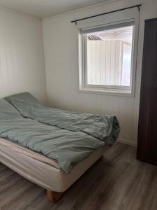 a unmade bed in a room with a window at Apartment in Senja in Senja