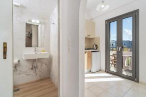 a white bathroom with a sink and a mirror at Lena Apartments in Elounda +75 photos