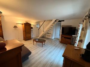 a living room with a staircase and a television at Gîte de groupe La Chapinière 7 min ZooParc Beauval in Châteauvieux