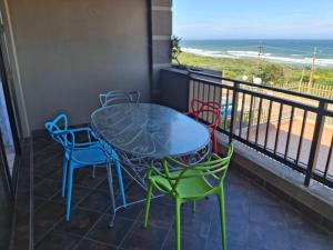 a table and chairs on a balcony with the beach at 28 Breaker View 3-bedroom beach apartment in Durban