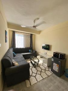 a living room with a couch and a tv at Milly's apartment in Malindi