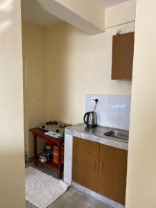 a small kitchen with a sink and a table at Milly's apartment in Malindi