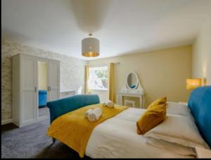 a bedroom with a large bed with two stuffed animals on it at Nith Riverside Cottages in Sanquhar
