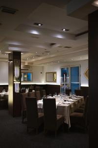 a dining room with a long table and chairs at Hotel Golf Luxury in Kruševac
