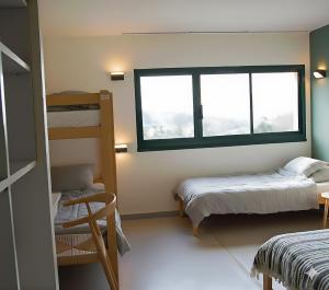 a bedroom with two bunk beds and a window at Ti menez Are in Brasparts