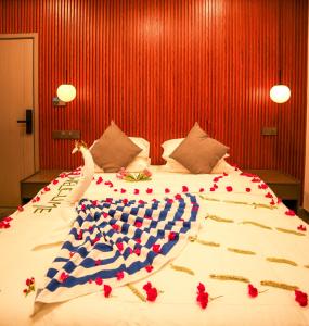 a large bed with red flowers on top of it at Sea Tides Dhangethi in Dhangethi +19 photos