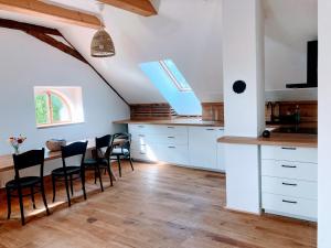 a kitchen with white cabinets and a table with chairs at Klobucká manufaktura in Valašské Klobouky