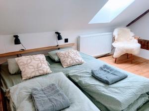 a bedroom with two beds and a chair at Klobucká manufaktura in Valašské Klobouky