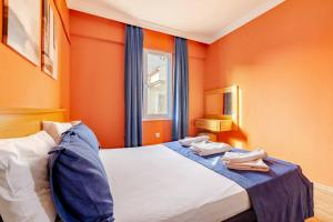 a bedroom with orange walls and a bed with towels on it at Nehir Apart Hotel in Fethiye