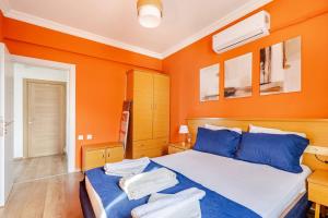 a bedroom with orange walls and a bed with blue pillows at Nehir Apart Hotel in Fethiye