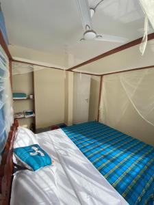 a bed in a small room in a boat at Milly's apartment in Malindi