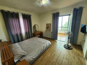 a bedroom with a bed and a window and a fan at HighLand Hotel in Aley