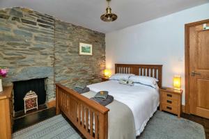 a bedroom with a large bed and a stone wall at Finest Retreats - Garreg Ddu in Blaenau-Ffestiniog