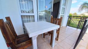 a white table and two chairs on a balcony at Come Home in Oudtshoorn Self-Catering Units in Oudtshoorn