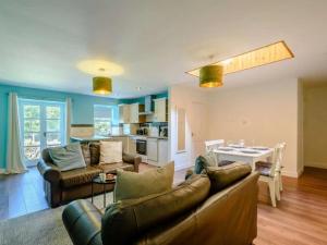 a living room with a couch and a table at Nith Riverside Cottages in Sanquhar