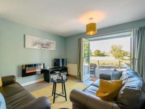 a living room with a couch and a table and a window at Nith Riverside Cottages in Sanquhar