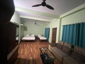 ein Wohnzimmer mit zwei Betten und einer Couch in der Unterkunft hotel tuki in Kawasoti