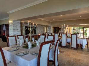 a dining room with a white table and chairs at Castle On The Heads in Knysna