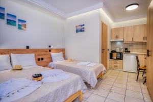 a hotel room with two beds and a kitchen at Christinas apartments in Ágios Matthaíos