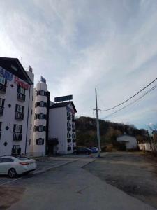 a parking lot in front of a white building at Hotelharu in Eumseong