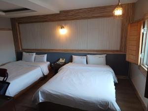 a room with two beds and a telephone in it at Hotelharu in Eumseong