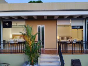 a house with a balcony with tables and chairs at Cerros de Anapoima in Anapoima
