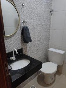 a bathroom with a sink and a toilet and a mirror at Pousada Horbis in Guarabira