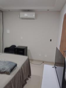 a room with a bed and a desk and a television at Pousada Horbis in Guarabira +9 photos