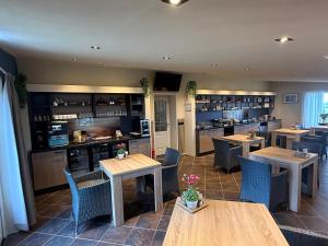 a restaurant with tables and chairs and a kitchen at B&B Plompetorenzicht in Burgh Haamstede