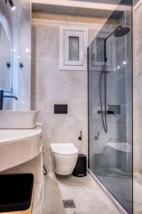 a bathroom with a shower and a toilet and a sink at Christinas apartments in Ágios Matthaíos