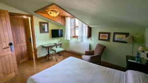 ein Schlafzimmer mit Bett, Schreibtisch und Fernseher in der Unterkunft Alojamientos Cenera in Cenera