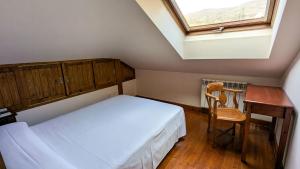 ein Schlafzimmer mit Bett, Schreibtisch und Fenster in der Unterkunft Alojamientos Cenera in Cenera