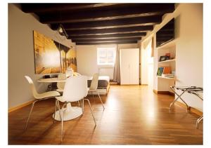 a living room with a table and white chairs at Just Here apartments - La mansarda in Bari