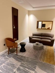 a living room with a couch and a chair at Saadatus Apartment in Kaduna +21 photos