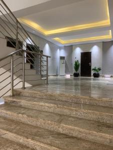 an empty lobby with stairs and a stair case at Saadatus Apartment in Kaduna