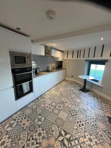 a kitchen with a tile floor with a table in it at Seaview Terrace in Skerries