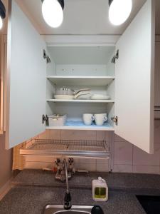 a kitchen with a sink and a shelf with pots and pans at Cozy Studio Cheonho in Seoul +7 photos