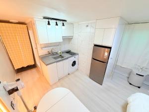 a small kitchen with a sink and a refrigerator at Cozy Studio Cheonho in Seoul