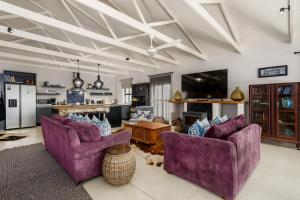 a living room with two purple chairs and a table at Inverell Station by The Oyster Collection in Kenton on Sea