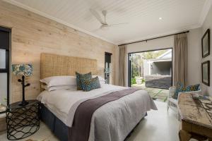 a bedroom with a bed and a sliding glass door at Inverell Station by The Oyster Collection in Kenton on Sea +25 photos