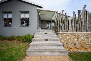 a wooden staircase in front of a house with a fence at Inverell Station by The Oyster Collection in Kenton on Sea