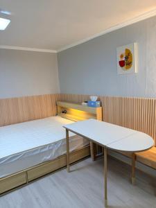 a small room with a bed and a table at Cozy Studio Cheonho in Seoul