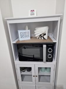 a white cabinet with a microwave in it at Vicolo Stretto Guest House Centro storico in Vibo Valentia