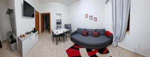 a living room with a blue couch and a table at Vicolo Stretto Guest House Centro storico in Vibo Valentia