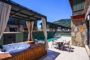 a bath tub on a deck with a table and chairs at champion villas in Ortaca